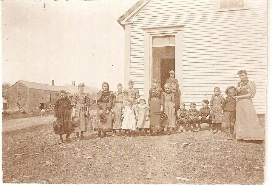 Picture from 1900 showing school children and their teacher outside the school.